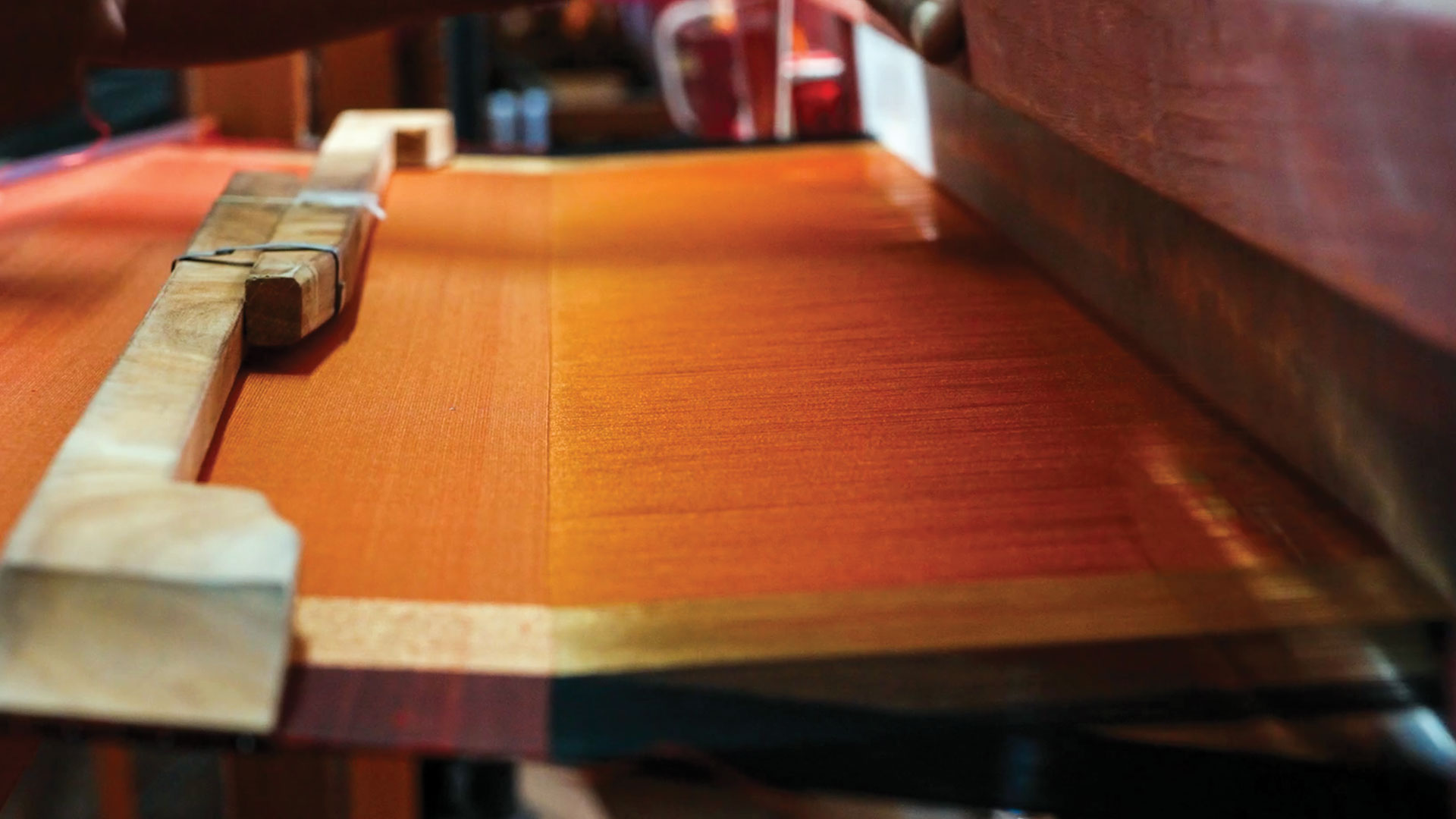 A yellow-orange shade of saree in a loom