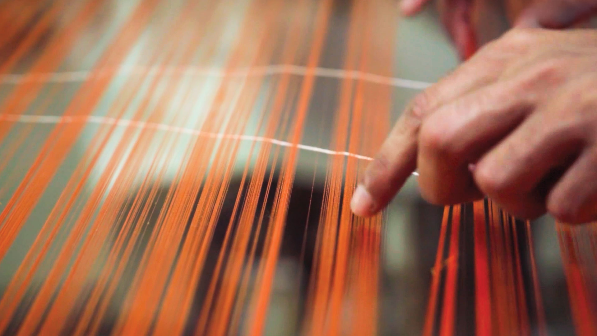 A group of artisans weaving intricate patterns into a saree